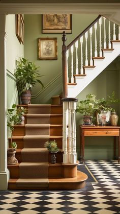 a staircase with potted plants next to it and framed pictures on the wall above