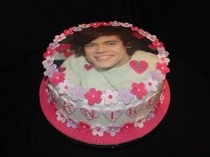 a cake decorated with flowers and a photo of a man on it's side