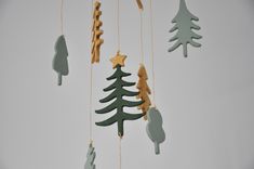 an ornament hanging from a string in the shape of a christmas tree with stars and trees on it