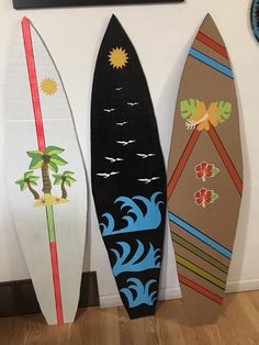 three surfboards are lined up against the wall in front of a painting on the wall