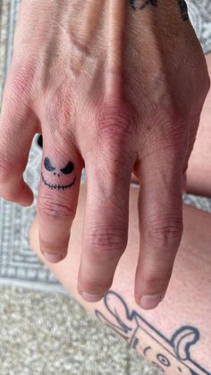 Small cute Jack Skellington finger tattoo Jack Skellington Finger Tattoo, Mens Small Finger Tattoos, Men's Small Tattoo Hand, Mens Tatoos Ideas Hand, Jack And Sally Finger Tattoo, Cool Hand Tats For Guys, Cool Small Tattoos For Men Simple, Small Tattoo Ideas On Fingers, Ring Finger Tattoo For Men Simple