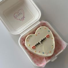 a heart shaped cake in a box with writing on it