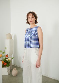 "The Crop top is a summer essential that goes well with other pieces in different shapes. Because of its heavy-looking wide hem and bust darts, the top helps you create an outstanding yet simple look that you can easily adjust for the occasion by playing around with additional layers or accessories. SIZING & FIT This garment is true to size, and we recommend choosing the size you usually wear. If you want the garment to be loose-fitting, choose a larger size than you usually wear. Before pla Linen Dress Summer, Gingham Linen, Gingham Top, Linen Tank Top, Linen Tank, Gingham Tops, Linen Jumpsuit, Summer Essential, Tank Top Dress