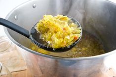 a ladle filled with food on top of a wooden table