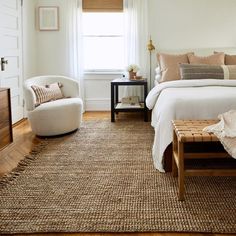 a bed room with a neatly made bed and two chairs