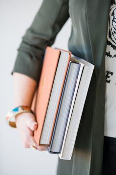 a person holding two books in their hands