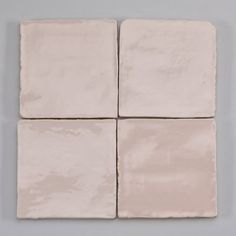 four white square tiles on a gray background