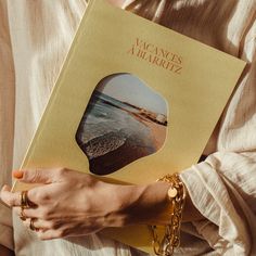 a woman holding a book in her hands with the cover open to show an image