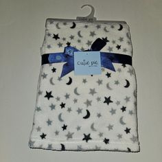 a white blanket with black stars and a blue ribbon on the front that says cutie pie