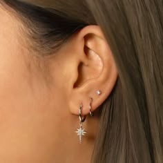 a close up of a woman's ear with two small stars on the side