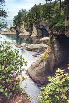 the water is running through an area with rocks and trees on either side of it