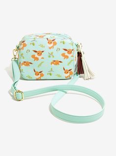 a small blue bag with an orange flower pattern on the front and tasseled strap