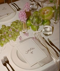 a table set with place settings, silverware and fruit on the table for a wedding reception