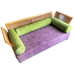 a purple and green couch sitting on top of a white floor next to a wooden frame