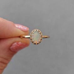 This antique style crown ring comes with a gorgeous Australian oval opal. If you want a different stone or want to add accent diamonds contact us for a quote. Details: - Default stone size is 7x5mm Australian Opal in oval shape. - Shiny finish by default. - Default width is 1.8mm at the bottom and 8.7x6.5mm at the top - Default thickness is 1.6mm at the bottom and 2mm at the top. - Contact us for quote if you want to customize this ring in any way. Thank you for shopping with Sevgi Jewelry! Classic Opal Oval Cabochon Ring For Promise, Classic Opal Oval Cabochon Promise Ring, Classic Oval Cabochon Opal Promise Ring, Classic Opal Promise Ring With Oval Cabochon, Elegant Opal Cabochon Promise Ring, Oval Opal Birthstone Ring In 14k Gold, Elegant Opal Promise Ring With Cabochon, 14k Gold Oval Opal Birthstone Ring, Elegant 14k Gold Oval Opal Ring