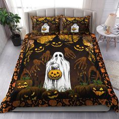 a bed covered in halloween themed comforters with pumpkins and ghost faces on it