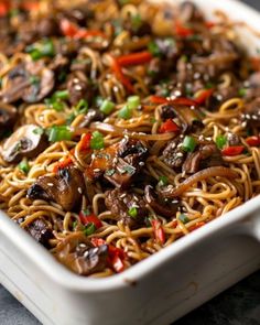 a white dish filled with noodles and mushrooms