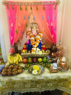 there is a ganeshi decoration on the table with fruit and other food items