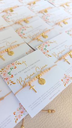 the wedding stationery is laid out on top of each other with gold cross pins