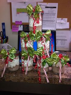 some candy canes wrapped in green and red ribbon are sitting on a counter top