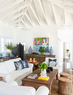 a living room filled with furniture and a painting on the wall above it's fireplace