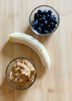 a banana, blueberries and peanut butter are on a wooden cutting board next to each other