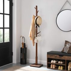 a coat rack with hats, shoes and umbrellas hanging on it next to a door