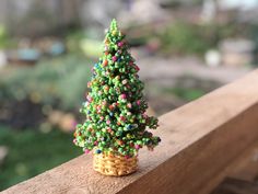 a small christmas tree sitting on top of a wooden fence