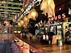 a man sitting at a bar with lots of lights hanging from the ceiling above him