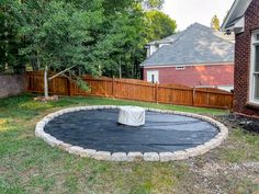 an empty backyard with a trampoline in the middle