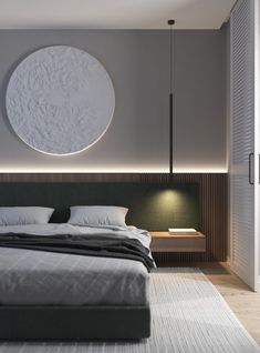 a large bed sitting under a round light in a bedroom