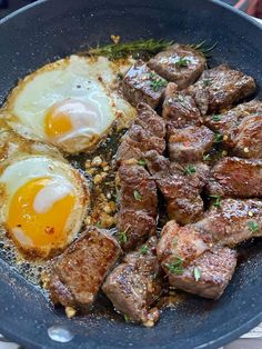 steak and eggs in a skillet with seasoning on the side, ready to be eaten