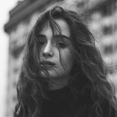 a black and white photo of a woman with long hair looking off to the side