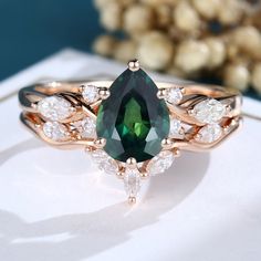 a green and white ring sitting on top of a table next to a flower arrangement