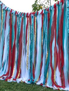 red, white and blue streamers are hanging from the side of a fence outside