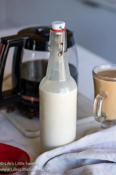 a bottle of milk next to a cup of coffee