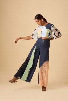 Tailored in a light weight poly-crepe, poly-suede and georgette, this boxy crop top has been crafted with irregular forms of appliqué details and layered ruffled sleeves. A perfect icebreaker for an office or a lounge wear. The pile of blue tones and pastels layer up, reflecting the frame of variegated colour block play. And this vintage- inspired high rise wide leg silhouette is adorned with refined pleating and panelling giving it more drama in textures and pattern. Shell Top: Fauxe Suede, Ind Indian Streetwear, Detail Couture, Trouser Pattern, Colorblock Pants, Boxy Crop Top, Color Block Top, Future Fashion, Colour Block, Fashion Sewing