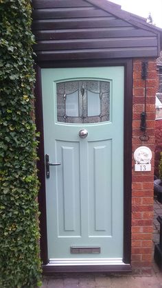 a blue front door sitting next to a brick building with ivy growing on it's sides