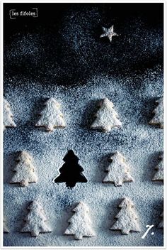 there are many small trees made out of powdered sugar on top of the cookie sheet