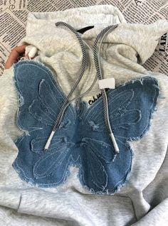 someone is holding a butterfly shaped sweatshirt with zippers on it's hoodie