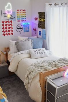 a bed room with a neatly made bed and lots of pictures on the wall above it