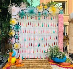 an outdoor display with umbrellas, plants and decorations on the side of the wall