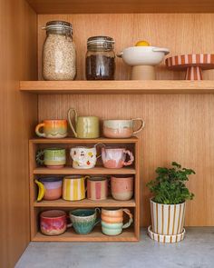 the shelves are filled with colorful dishes and cups