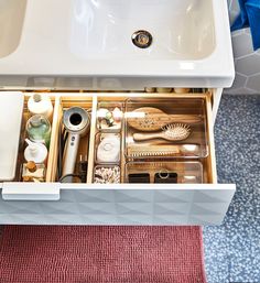 an open drawer in a bathroom with toothbrushes and other items