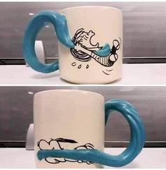 two coffee mugs with blue handles and cartoon images on them, one has a handle