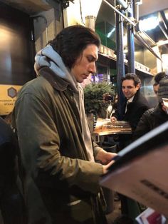 a man standing in front of a table with food on it and people around him