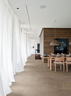 a dining room with white drapes covering the walls and floor next to a table