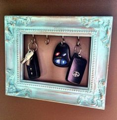 there are four keys hanging in a frame with the keychains attached to it