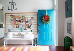 a room with a blue door and a colorful rug on the floor in front of it