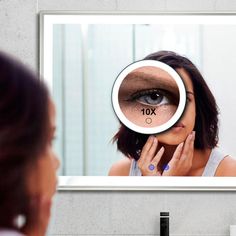 a woman looking at her reflection in the mirror